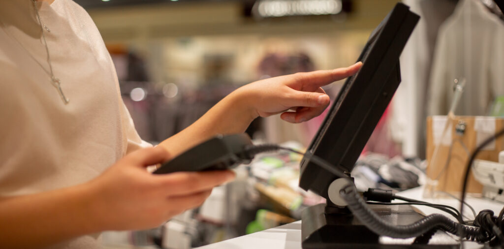 Saleswoman uses POS system to help customer check out. Store items that have been updated using TGP Copy/Paste.